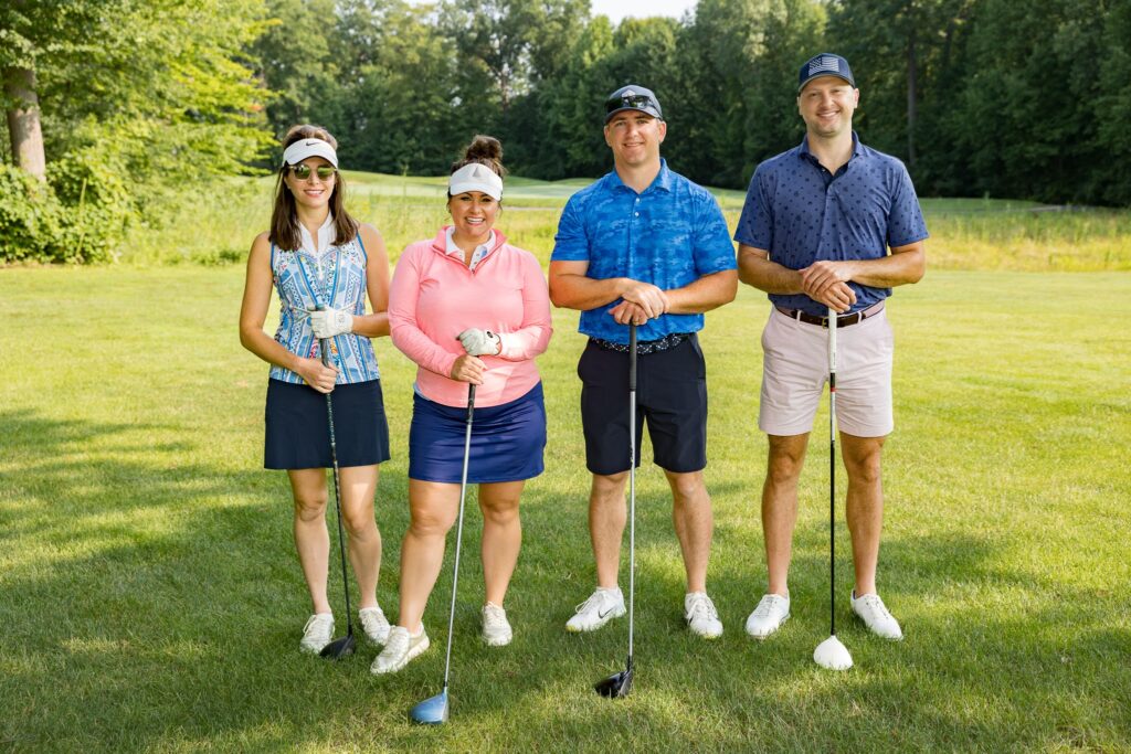 WID: a group of two woman and two men stand next to each other for a photo at the golf scholarship outing 2023