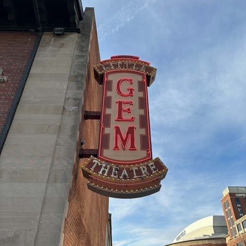 The Gem Theatre sign featuring the sky behind it in Detroit, Michigan.