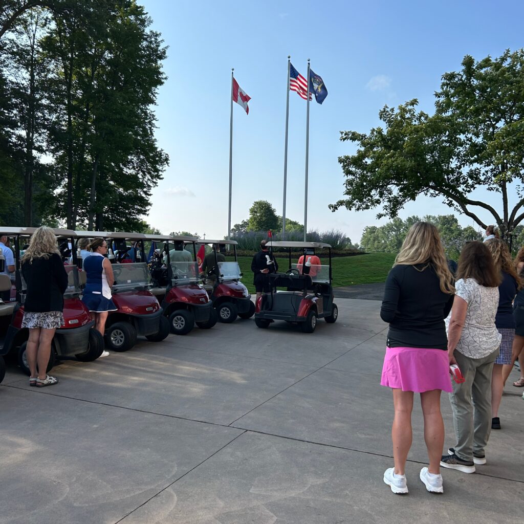 Members of WID Michigan place their hands over their hearts and observe the flag at the Annual Golf Outing.